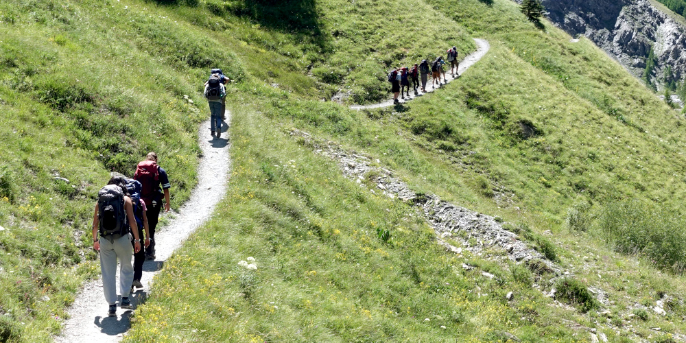 Des adolescents du Trièves marchant sur un sentier de montagne vers un refuge de montagne